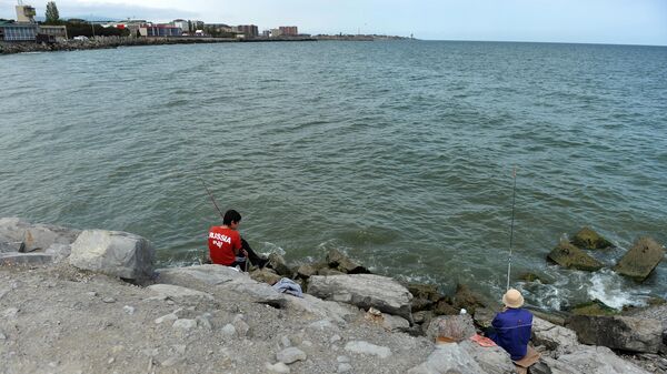 Рыбаки на набережной города Каспийска в Дагестане