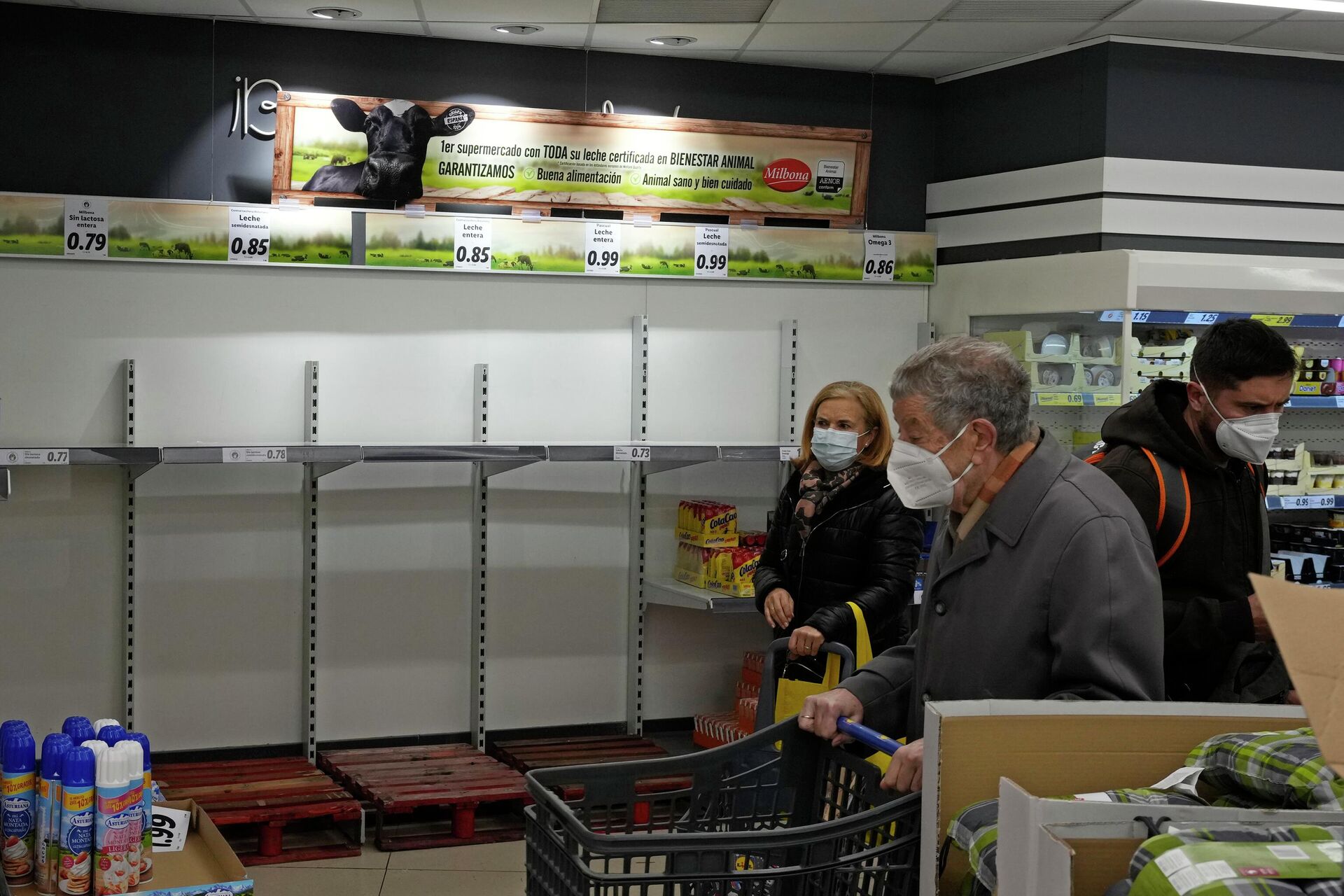 Покупатели проходят мимо пустых полок, где обычно выставлено молоко, в супермаркете в Мадриде, Испания - РИА Новости, 1920, 17.06.2022