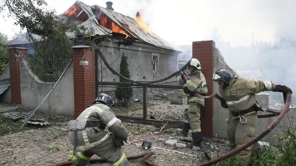 Сотрудники МЧС ДНР во время тушения пожара, возникшего в результате обстрела со стороны ВСУ Киевского района Донецка