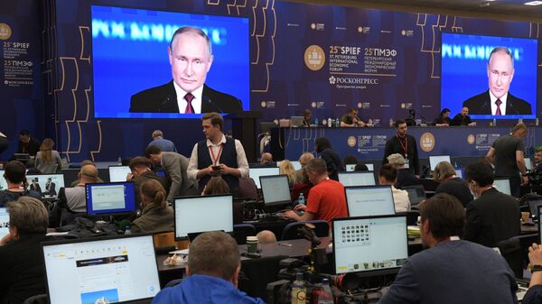 Экраны с трансляцией выступления президента Путина на пленарном заседании XXV ПМЭФ