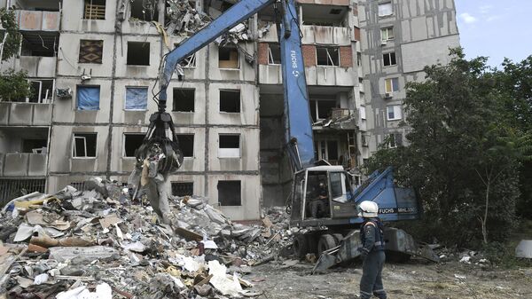 Сотрудники МЧС России разбирают завалы разрушенного дома на одной из улиц в Мариуполе