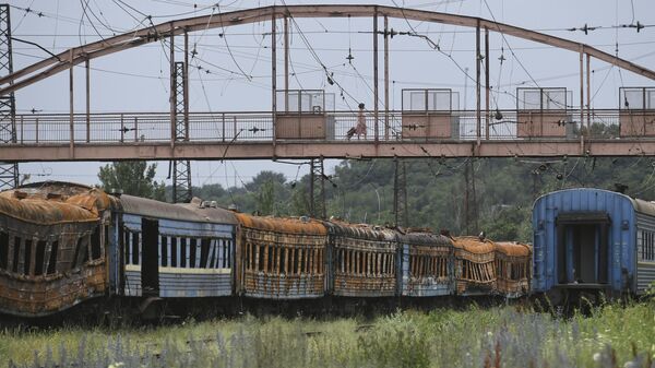 Сгоревшие вагоны у разрушенного железнодорожного вокзала в Мариуполе