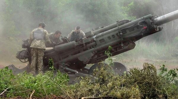 Украинские солдаты ведут обстрел из американской гаубицы М777
