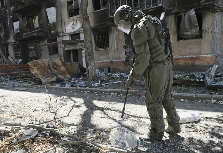 Сапер Международного противоминного центра Вооруженных сил РФ во время обхода жилых домов, прилегающих к территории металлургического комбината Азовсталь в Мариуполе с целью разминирования 