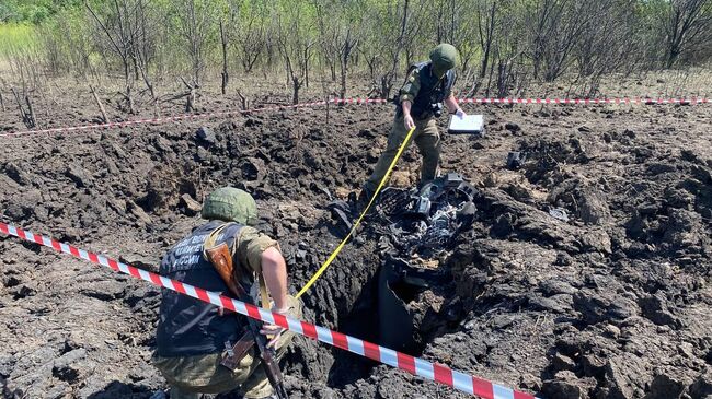 Следователи СК РФ работают на месте попадания ракеты Точка-У в городе Зимогорье в ЛНР. 21 июня 2022