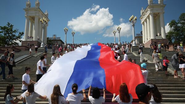Жители Волгограда несут стометровый флаг России по центру города (флешмоб посвящен Дню России)