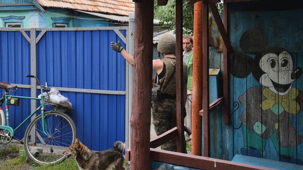 Боец Народной милиции ЛНР общается с жителем поселка Ивановка (окраина города Горское) во время проведения зачистки Горского
