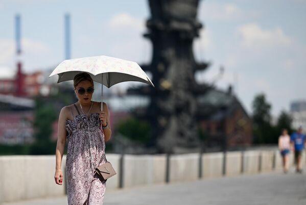 Девушка под зонтом в жаркую погоду в Москве