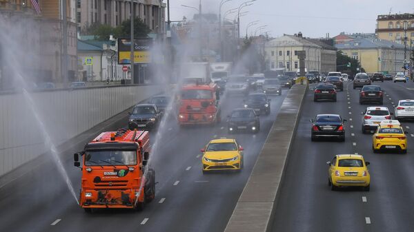 Автомобили коммунальной службы производят аэрацию проезжей части дороги на Новинском бульваре в Москве