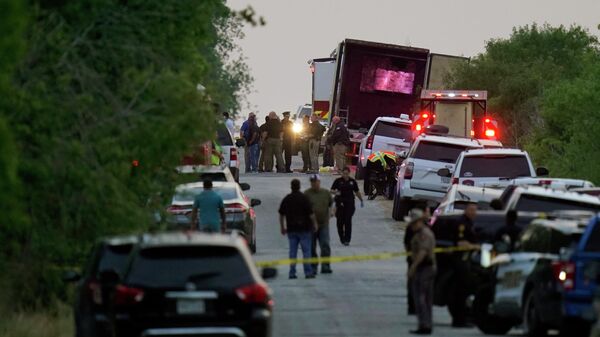 Сотрудники экстренных служб рядом с фурой, в которой были обнаружены тела мигрантов. Сан Антонио, Техас