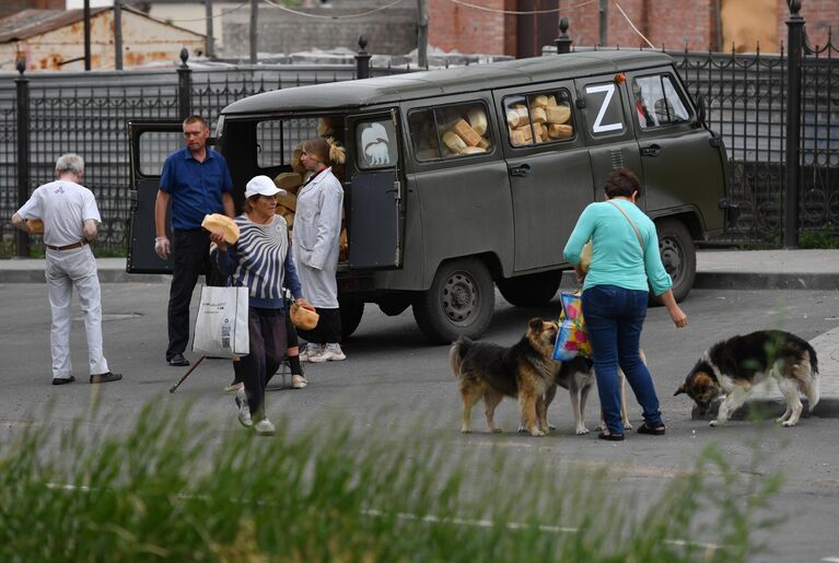 Местные жители у передвижного пункта гуманитарной помощи возле Покровского храма в Мариуполе