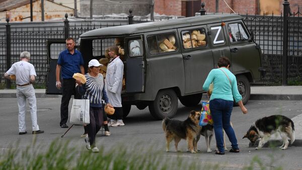Местные жители у передвижного пункта гуманитарной помощи возле Покровского храма в Мариуполе