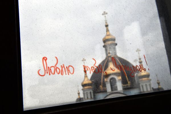 Надпись на стекле - Люблю тебя, Мариуполь!. На втором плане - Покровский храм в Мариуполе