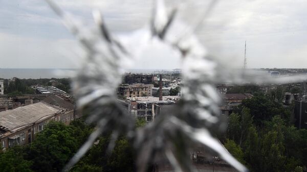 Вид с водонапорной башни через разбитое стекло на Соборную улицу и портовую часть города Мариуполя