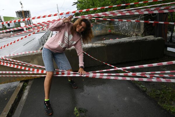 Девушка пересекает ограждение на автомобильном мосту через реку Салгир в Симферополе, на котором, предположительно, из-за подъема воды образовался провал