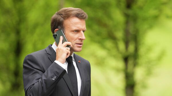 Президент Франции Эммануэль Макрон говорит по телефону на саммите G7 в замке Эльмау
