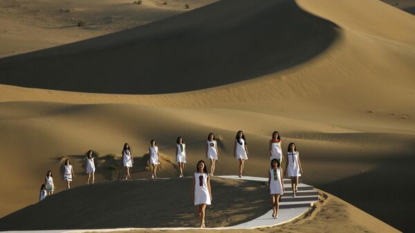 Модели во время показа коллекции Пьера Кардена весна-лето 2008 в пустыне на окраине китайского города Дуньхуан