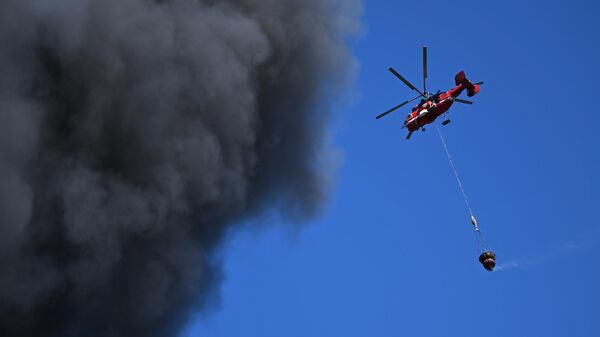 Вертолет МЧС РФ тушит пожар в промышленной зоне на Каширском шоссе в Москве
