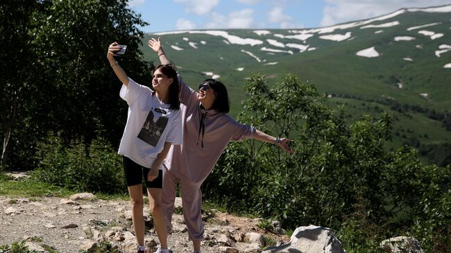 Туристы фотографируются на смотровой площадке плато Лаго-Наки в Адыгее