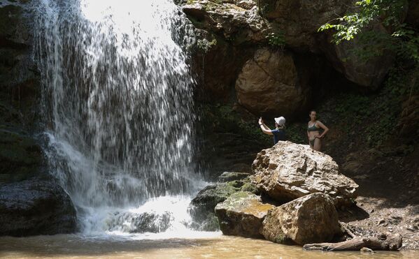 Туристы у водопада в ущелье Руфабго в Адыгее