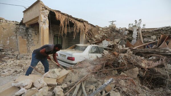 Мужчина убирает завалы после землетрясения в Иране