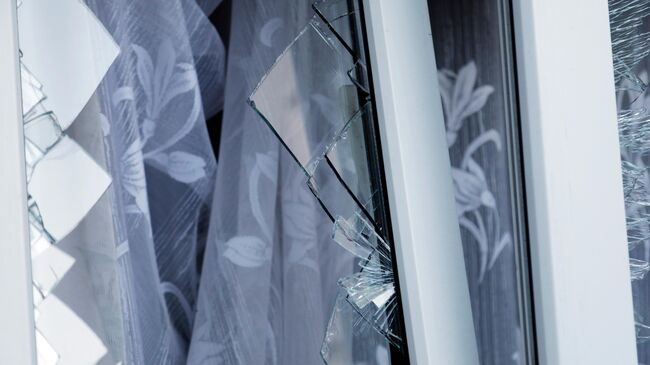 Разбитое в результате обстрела ВСУ стекло в окне жилого дома. Архивное фото