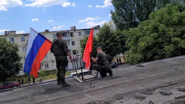 Жители Лисичанска поднимают Знамена Победы и российские триколоры
