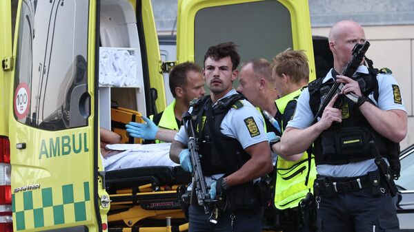 Сотрудники полиции и скорой помощи  во время эвакуации людей из торгового центра в Копенгагене после сообщений о стрельбе