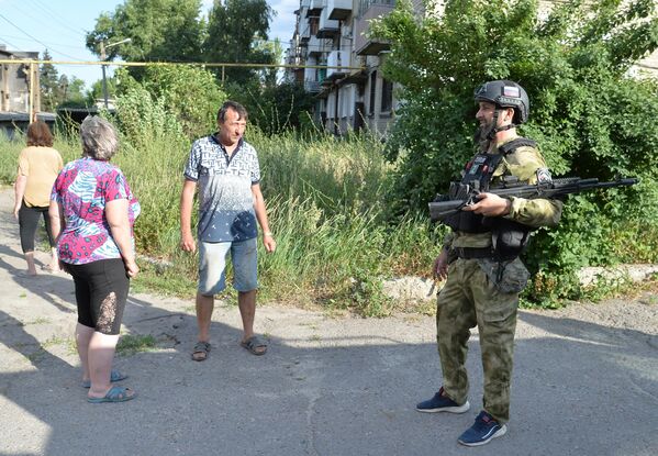 Боец специального полка полиции имени Героя России Ахмата-Хаджи Кадырова общается с местными жителями в Лисичанске
