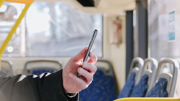 Мужчина с телефоном в салоне автобуса