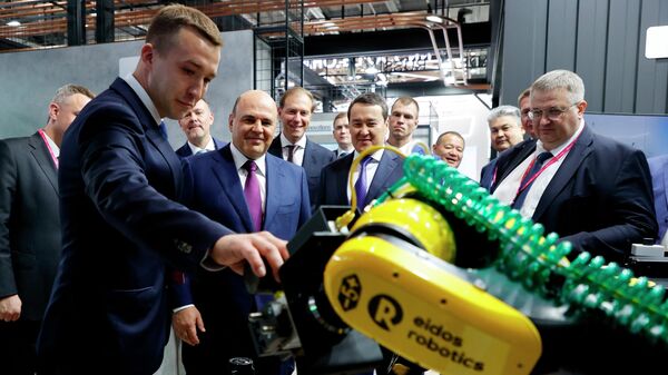 Председатель правительства РФ Михаил Мишустин у стенда с роботом-манипулятором А12 компании Эйдос-Робототехника на международной промышленной выставке Иннопром-2022