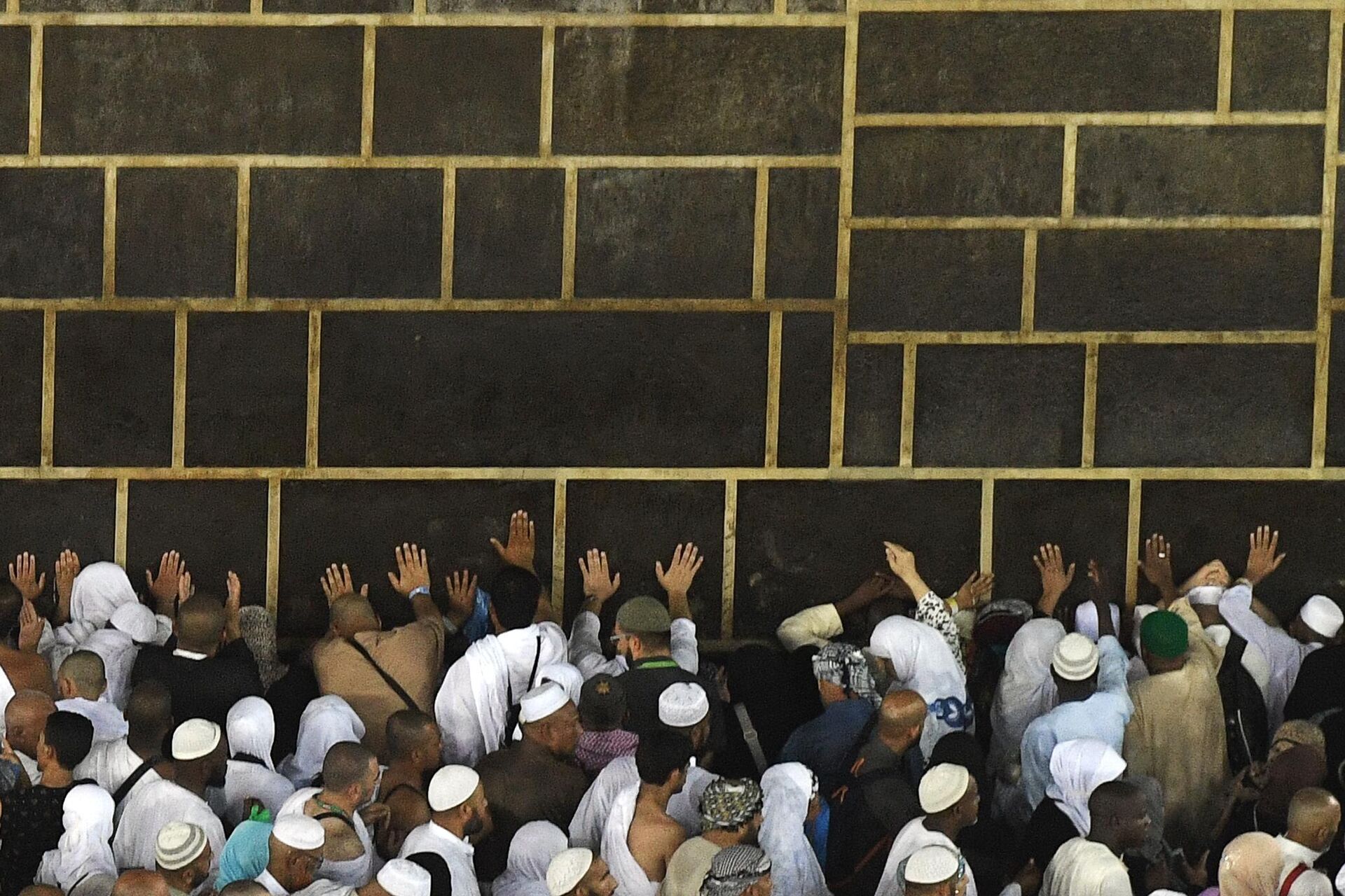 Паломники во время хаджа дотрагиваются до Каабы во время обхода вокруг нее в мечети Масджид аль-Харам в Мекке - РИА Новости, 1920, 05.07.2022