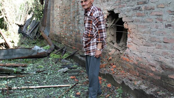 Местный житель у жилого дома, пострадавшего в результате обстрелов украинскими силовиками города Горловки в Донецкой области. 