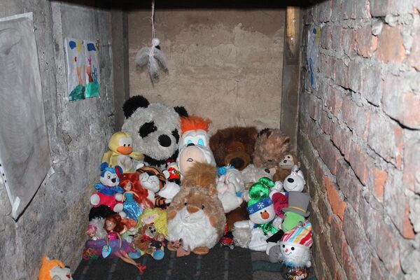 Детские игрушки и рисунки в подвале, где живут люди с детьми в поселке Спартак в Донецкой области.