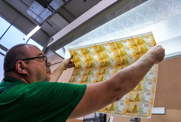 Сотрудник выполняет поэкземплярный контроль новых 100-рублевых денежных купюра на фабрике АО Гознак в Москве