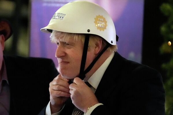 Премьер-министр Великобритании Борис Джонсон надевает велосипедный шлем