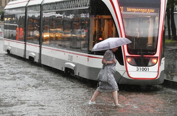 Женщина идет под зонтом во время дождя в Москве