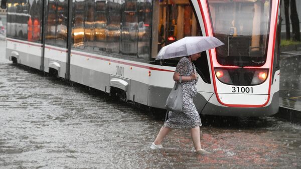 Женщина идет под зонтом во время дождя в Москве