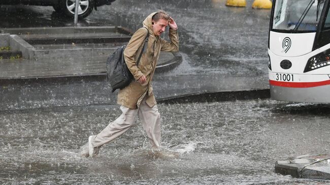 Прохожий во время дождя в Москве