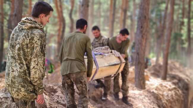 Украинские военнослужащие помогают хоронить своих сослуживцев в Старобельске