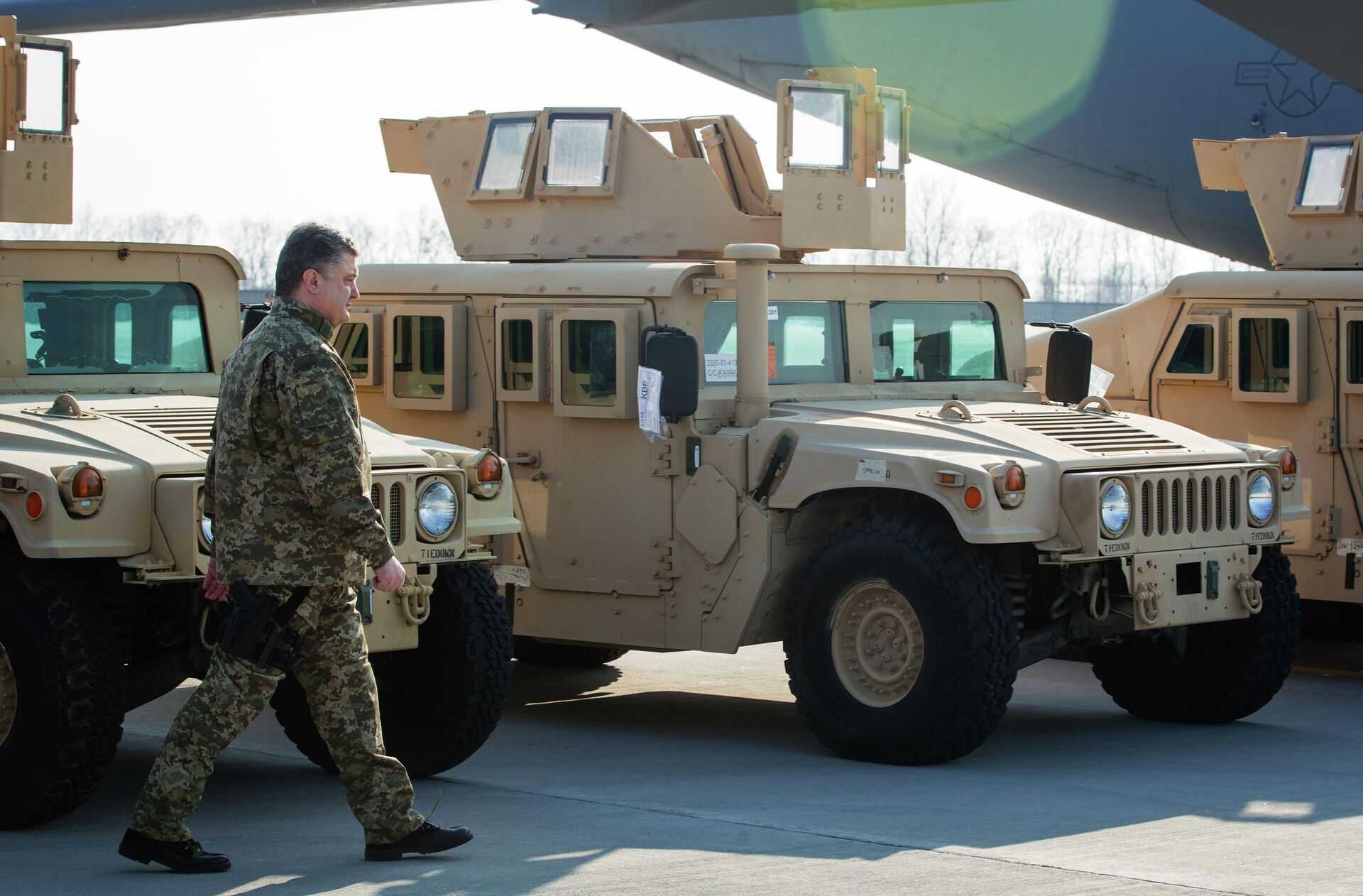 Президент Украины Петр Порошенко в 2015 году осматривает автомобили HMMWV во время церемонии встречи самолета Военно-воздушных сил США с первой партией американских бронированных автомобилей в международном аэропорту Борисполь. - РИА Новости, 1920, 11.07.2022