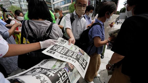 Сотрудник распространяет дополнительные выпуски газеты Yomiuri Shimbun с сообщением о покушении на бывшего премьер-министра Японии Синдзо Абэ. 