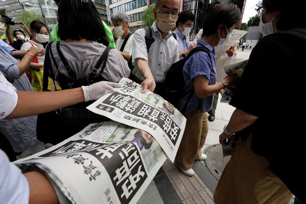 Сотрудник распространяет дополнительные выпуски газеты Yomiuri Shimbun с сообщением о покушении на бывшего премьер-министра Японии Синдзо Абэ. 