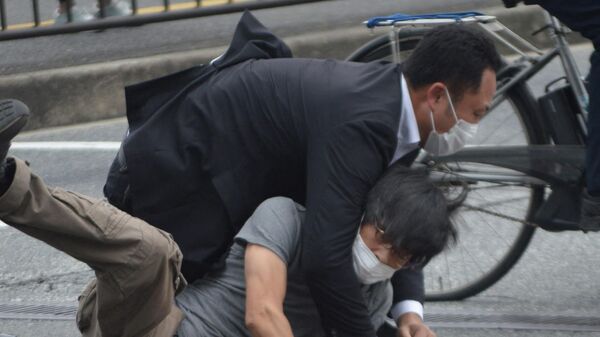 Мужчина (внизу), подозреваемый в стрельбе по бывшему премьер-министру Японии Синдзо Абэ, повален на землю полицией на станции Ямато Сайдайдзи в городе Нара.