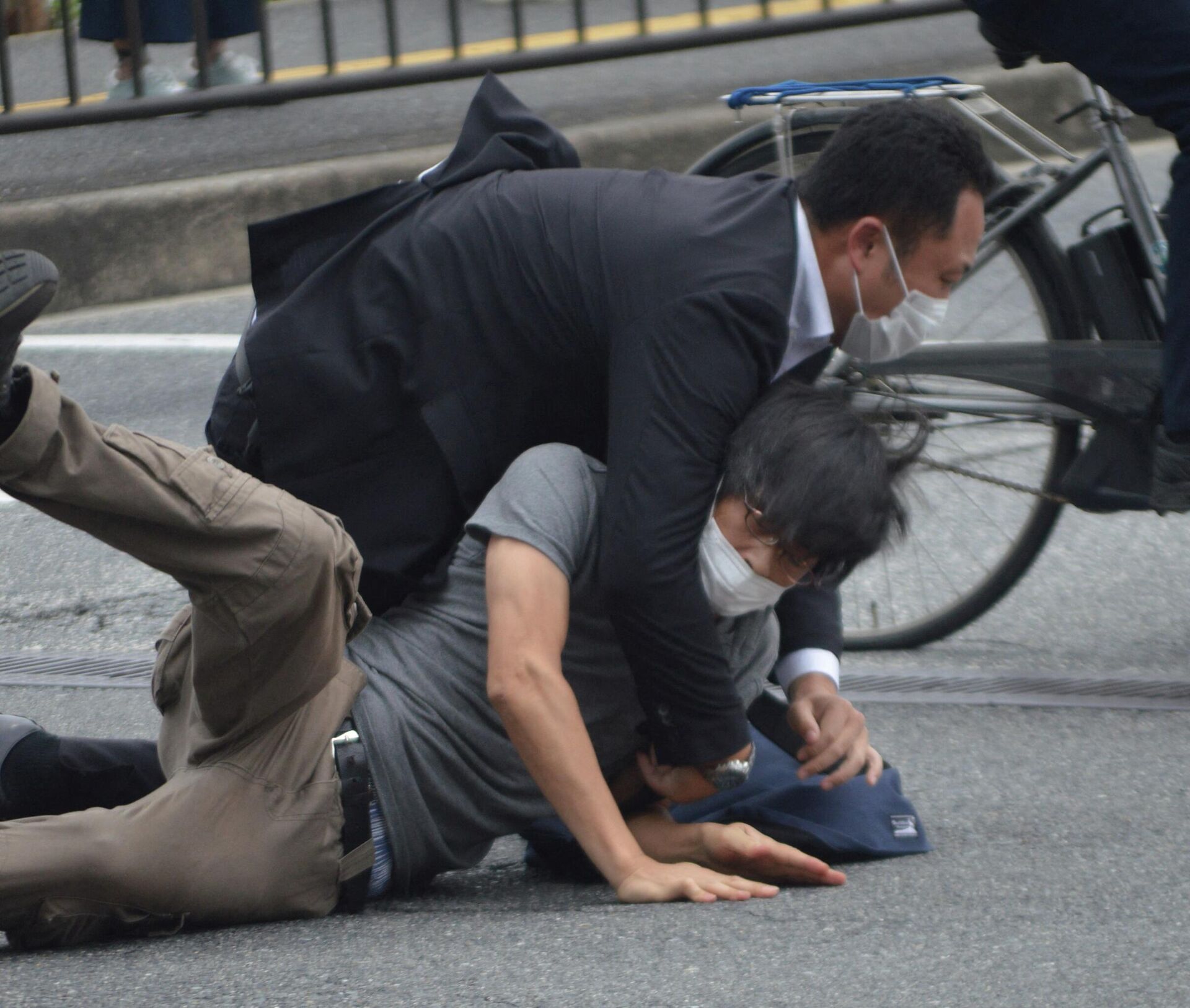Мужчина (внизу), подозреваемый в стрельбе по бывшему премьер-министру Японии Синдзо Абэ, повален на землю полицией на станции Ямато Сайдайдзи в городе Нара - РИА Новости, 1920, 08.07.2022