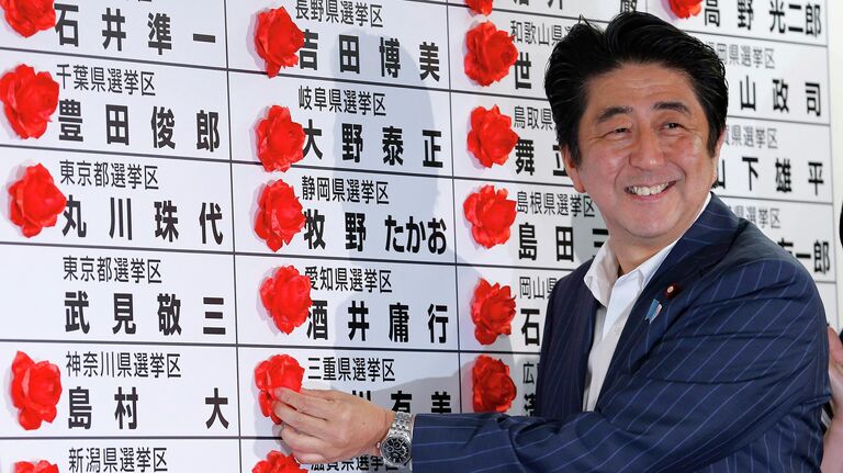 Премьер-министр Японии Синдзо Абэ ставит красную розочку на имя победившего кандидата от своей партии во время подсчета голосов на выборах в верхнюю палату парламента. 21 июля 2013 