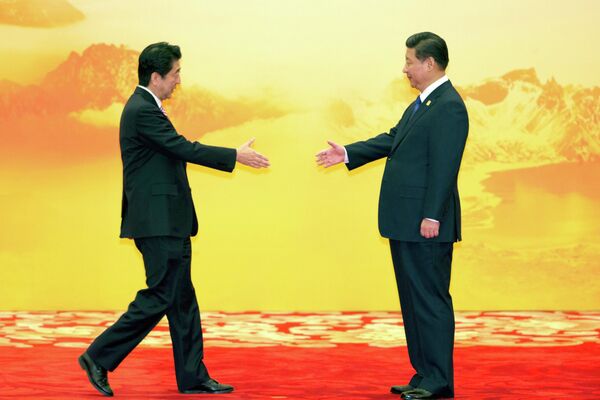 Премьер-министр Японии Синдзо Абэ и председатель КНР Си Цзиньпин во время церемонии приветствия встречи экономических лидеров Азиатско-Тихоокеанского экономического сотрудничества (АТЭС) в Пекине. 11 ноября 2014 года