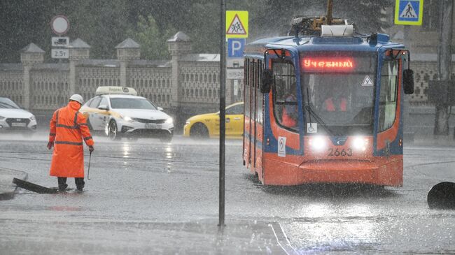 Сотрудник коммунальных служб во время дождя в Москве