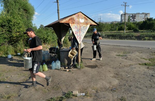 Жители набирают воду в колодце на окраине Лисичанска