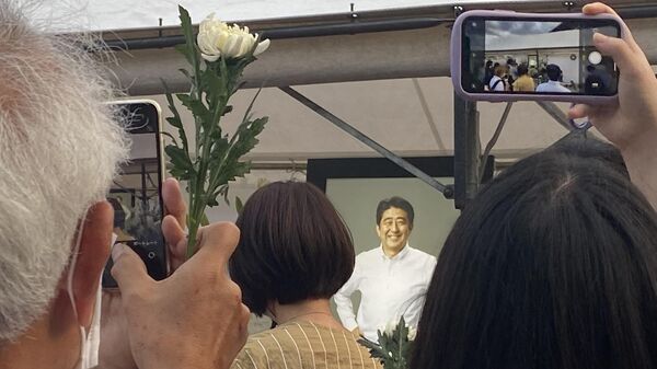 Люди на церемонии прощания с бывшим премьер-министром Японии Синдзо Абэ в буддийском храме Дзодзедзи в центре Токио